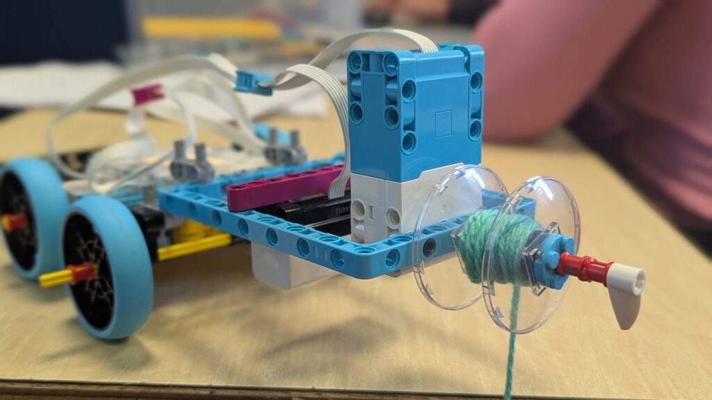 Véhicule LEGO équipé d'un moteur et d'un treuil qui enroule une ficelle sur une bobine