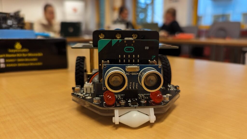 Petit robot à roues piloté par une carte micro:bit, avec un capteur à ultrasons à l'avant