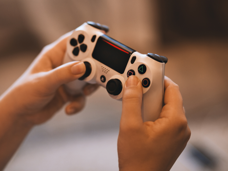 Mains tenant une manette de console de jeu