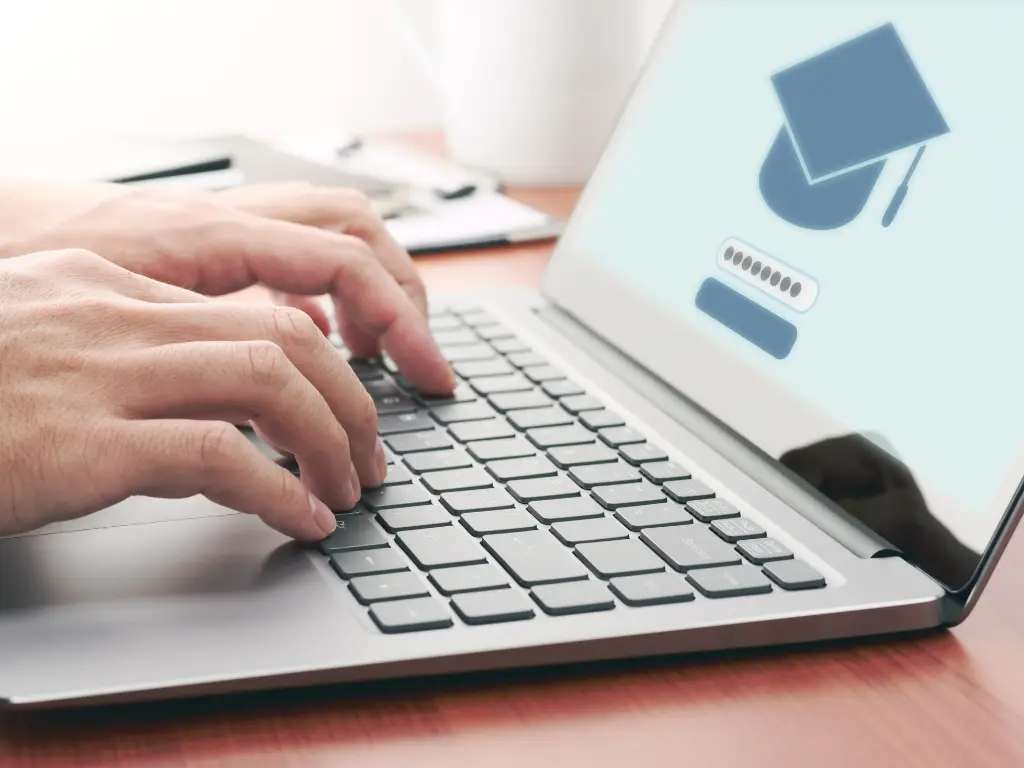 Mains tapant sur le clavier d’un ordinateur portable affichant une page de connexion à une formation en ligne