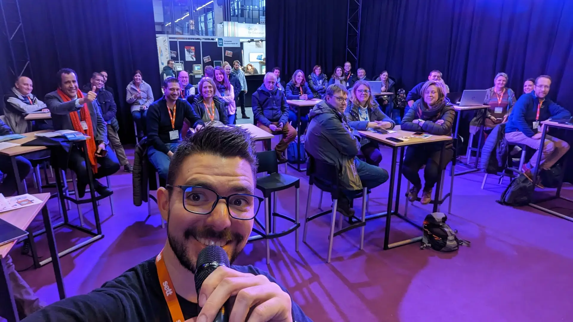 Tommy Berben, micro en main, avec un groupe d’enseignants souriants en formation